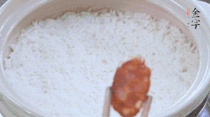 煮開(kāi)后轉(zhuǎn)小火，當(dāng)米飯出現(xiàn)小孔時(shí)，鋪上金字麻辣香腸。