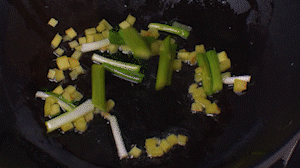 鍋中熱油，依次下姜粒、蔥段、蘆筍炒香。