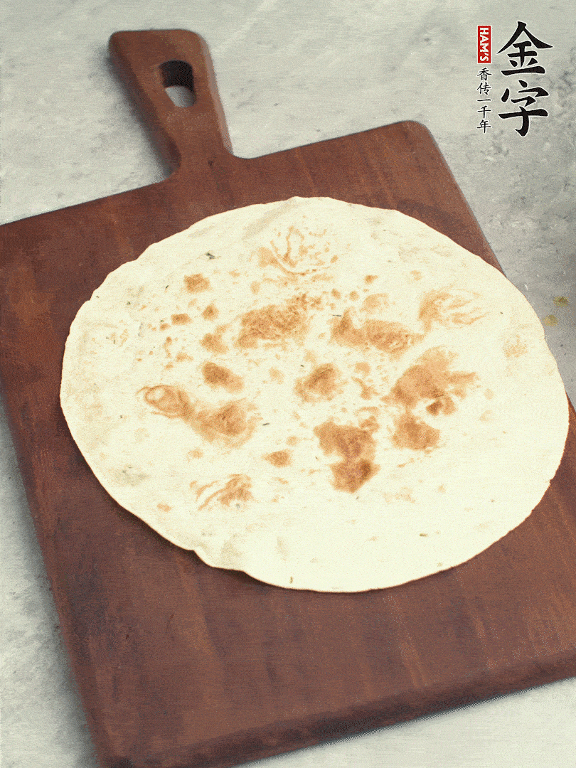 食材依次鋪在卷餅皮上，卷起來。