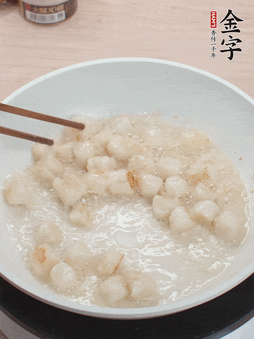 油溫4成熱，鮮貝蘸干淀粉下鍋煎，一面微黃后翻面。