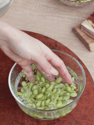 青豆剝殼，搓去外衣。