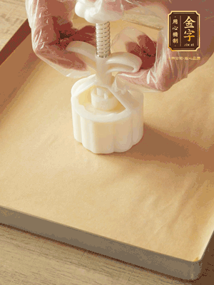 取一個面團(tuán)，捏扁，中間厚，四周薄。虎口往上推，直到收口，把餅胚放入模具里，壓2-3下