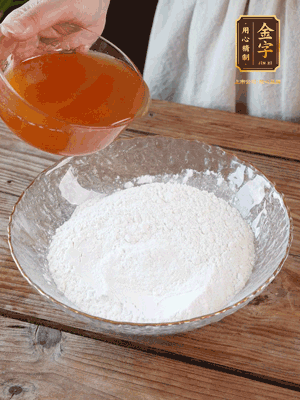 轉(zhuǎn)化糖漿、枧水、花生油攪拌均勻，加入面粉混合，醒發(fā)2小時。捏成23g一個的小球