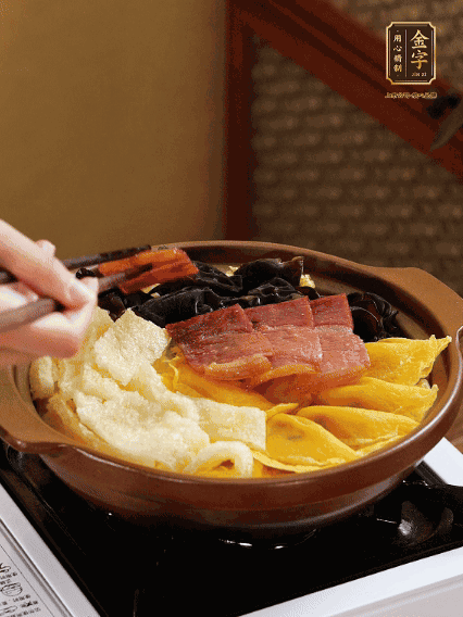 砂鍋底部鋪上娃娃菜，依次擺上肉皮、蛋餃、黑木耳、火腿